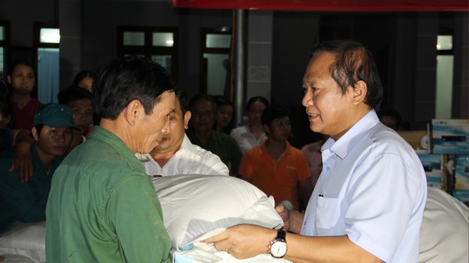 Bộ trưởng Trương Minh Tuấn ân cần trao quà cho các gia đình chịu thiệt hại vì đợt lũ lụt vừa qua.