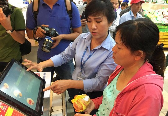 Nhân viên Co.opmart Foodcosa Quang Trung (Gò Vấp) hướng dẫn khách hàng cách kiểm tra nguồn gốc thịt heo bằng máy soi đặt tại siêu thị