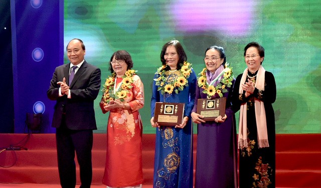 Thủ tướng Nguyễn Xuân Phúc (trái) và Nguyên Phó Chủ tịch nước Nguyễn Thị Doan (phải) tặng hoa cho các phụ nữ điển hình tiên tiến.