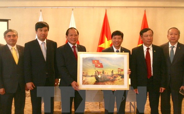 Bộ trưởng Bộ Thông tin và Truyền thông Trương Minh Tuấn tặng tượng trưng một bức ảnh cho Đại sứ quán Việt Nam tại Nhật Bản. (Ảnh: Nguyễn Tuyến/TTXVN)