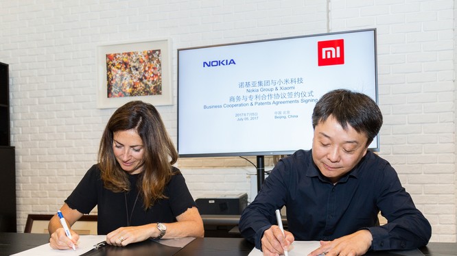 Trưởng phòng Pháp chế của Nokia - bà Maria Varsellona ký thỏa thuận hợp tác với ông Wang Xiang, Phó Chủ tịch Cấp cao của Xiaomi.