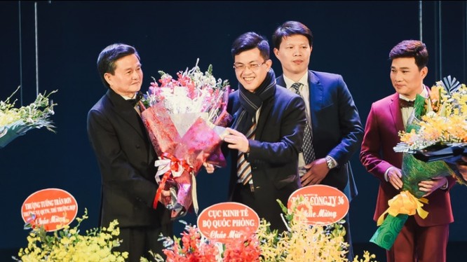 Đại tá Nguyễn Đăng Giáp (trái) được trao hoa và tôn vinh trong đêm nhạc.