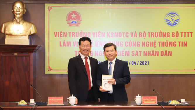 Bộ trưởng Nguyễn Mạnh Hùng tặng cuốn "Cẩm nang chuyển đổi số" cho Viện trưởng VKSNDTS Lê Minh Trí. Ảnh: VKSNDTC