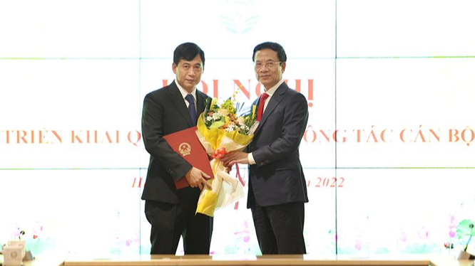 Bộ trưởng Nguyễn Mạnh Hùng trao quyết định và tặng hoa chúc mừng ông Nguyễn Thành Phúc.
