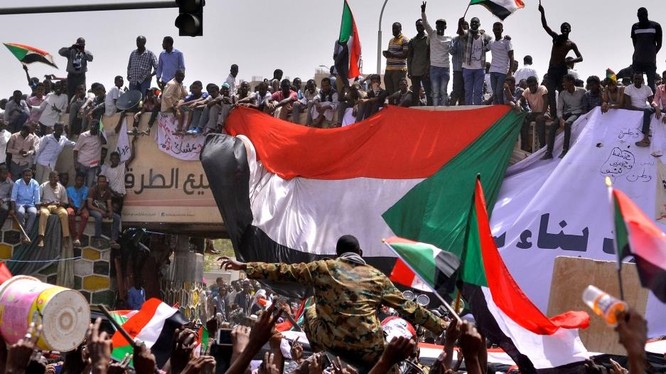 Một sĩ quan quân đội đứng giữa đám đông người biểu tình ở Thủ đô Khartoum, Sudan (Ảnh: Reuters)