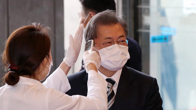 Tổng thống Hàn Quốc Moon Jae-in được đeo khẩu trang và kiểm tra thân nhiệt trước khi vào tòa nhà Quốc hội ở Seoul trong hôm 28/2 (Ảnh: Yonhap)