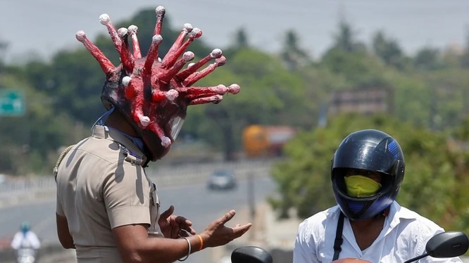 Cảnh sát ở thành phố Chennai đội mũ tạo hình giống virus corona để thực thi lệnh phong tỏa trong đại dịch COVID-19 (Ảnh: Reuters)