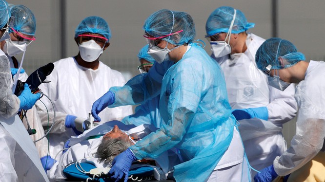 Nhân viên y tế Pháp chuyển một bệnh nhân COVID-19 trên cáng cứu thương (Ảnh: RT)