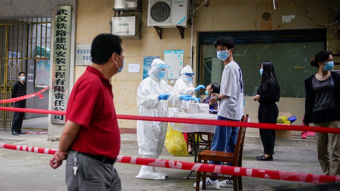 Nhân viên y tế mang đồ bảo hộ xét nghiệm COVID-19 cho người dân tại một khu dân cư ở Vũ Hán, tỉnh Hồ Bắc, Trung Quốc (Ảnh: Reuters)