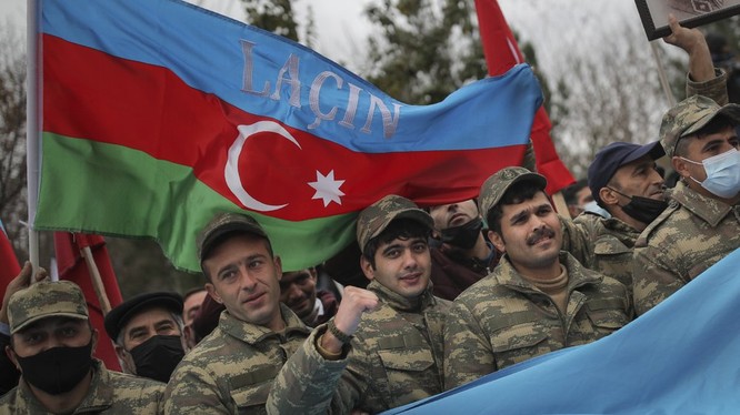 Binh sĩ Azerbaijan giơ cao lá quốc kỳ bên trên có dòng chữ "Lachin" để ăn mừng chiến thắng (Ảnh: AP)