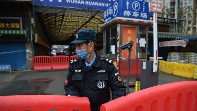 Một nhân viên bảo an đứng giám sát bên ngoài chợ hải sản Hoa Nam (Ảnh: AFP)