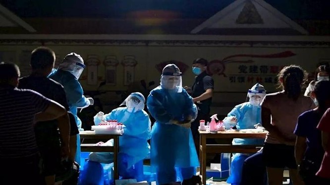 Nhân viên y tế lấy mẫu xét nghiệm Covid-19 cho người dân ở Thụy Lệ, tỉnh Vân Nam, Trung Quốc hôm 30/3. Ảnh: AFP.