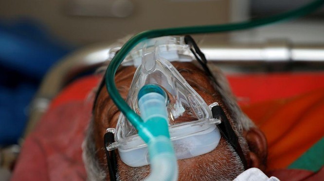 Một bệnh nhân được cho thở bình oxy trong xe cấp cứu, chờ được nhập viện điều trị COVID-19 (Ảnh: Reuters)