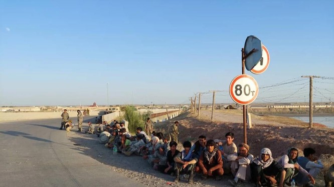 Các binh sĩ Afghanistan ngồi bên một cây cầu gần biên giới với Tajiskistan hồi tháng 6/2021 (Ảnh: AP)