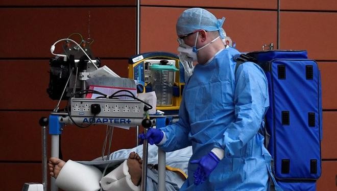 Một nhân viên y tế Anh chăm sóc bệnh nhân Covid-19 (Ảnh Reuters)