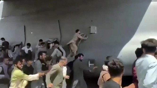 Hình ảnh kịch tính cho thấy nhiều người Afghanistan cố bám víu lấy chiếc máy bay quân sự Mỹ ở sân bay Kabul (Ảnh: AP)
