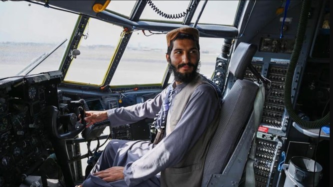 Chiến binh Taliban ngồi trên một chiếc máy bay quân sự mà Mỹ bỏ lại sau khi rút khỏi sân bay Kabul (Ảnh: AFP)