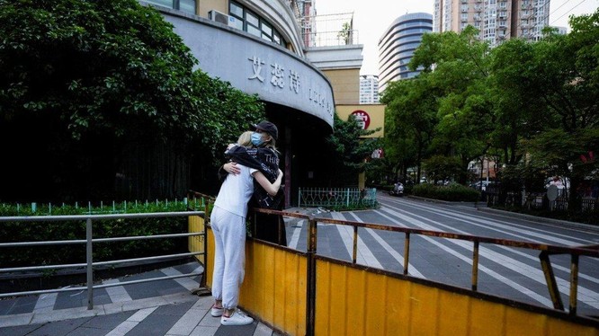 Hai cô gái đứng ôm nhau qua hàng rào, giữa lúc phong tỏa tại thành phố Thượng Hải, ngày 16/5 (Ảnh: SCMP)