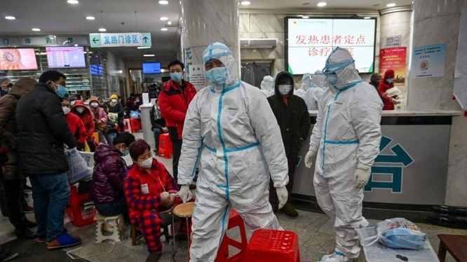 Nhân viên y tế đi bên cạnh bệnh nhân (trái) chờ chăm sóc y tế tại Bệnh viện chữ thập đỏ Vũ Hán. Ảnh: AFP