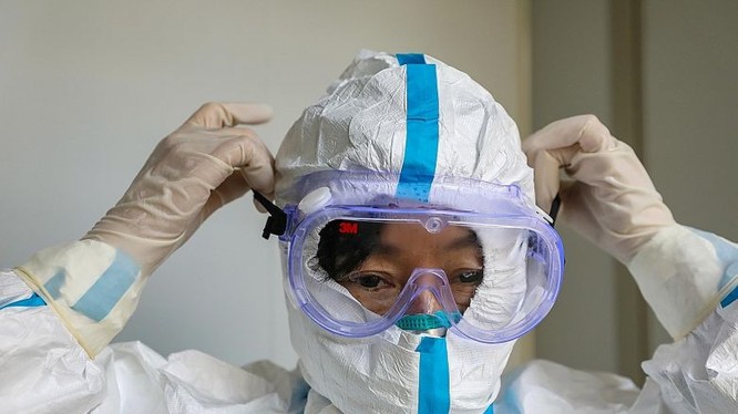 Nhân viên y tế đeo khẩu trang, mặc quần áo bảo hộ. Ảnh: Reuters
