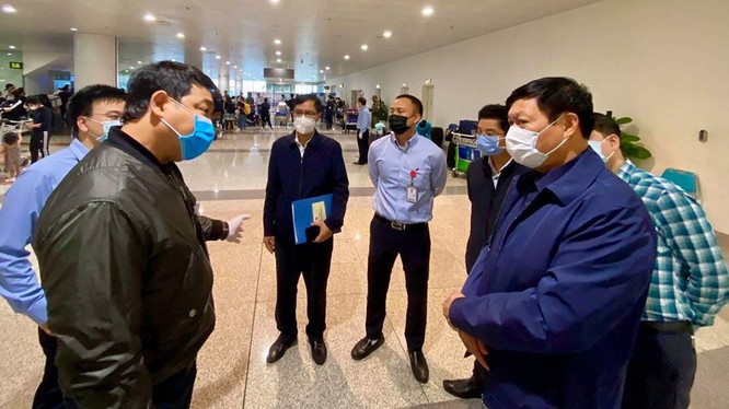 Thứ trưởng Bộ Y tế Đỗ Xuân Tuyên (áo xanh, đeo khẩu trang trắng, bên phải) kiểm tra, chỉ đạo công tác phòng chống dịch COVID-19 tại sân bay quốc tế Nội Bài. Ảnh: Minh Thư