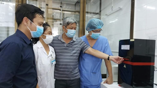 Thứ trưởng Bộ Y tế Nguyễn Trường Sơn (Áo sọc xám) tại buổi khai trương hệ thống xét nghiệm virus SARS-CoV-2 ở Bệnh viện C Đà Nẵng (Ảnh: Vũ Mạnh Cường) 