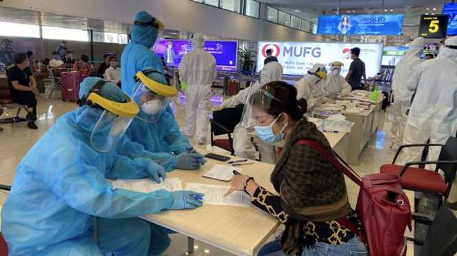 Nhân viên y tế hướng dẫn hành khách khai báo y tế ngay tại sân bay (Ảnh - Hồng Hạnh) 