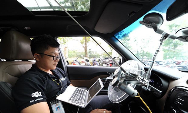 Kỹ sư trẻ Thái Vin đang theo dõi dữ liệu trên máy tính trong khi xe chạy với tốc độ hơn 20km/h ở khuôn viên toà nhà F-Town, quận 9. Ảnh: FPT.