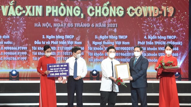 Thủ tướng Chính phủ Phạm Minh Chính trao chứng nhận, cảm ơn em Lê Đức Hiếu (15 tuổi), học sinh Trường Phạm Hồng Thái, Ba Đình, Hà Nội ủng hộ Quỹ vaccine phòng, chống dịch Covid-19.