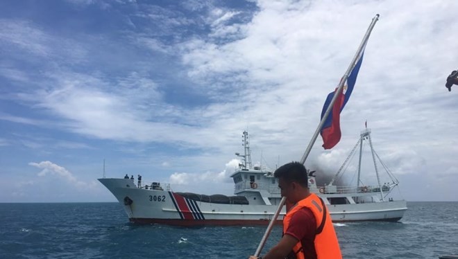 Một thành viên của nhóm Kalayaan Atin Ito đang thực hiện cắm quốc kỳ Philippines trên bãi cạn Scarborough nhưng bị Trung Quốc cản trở.
