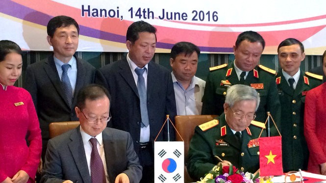 Thượng tướng Nguyễn Chí Vịnh (phải) và ông Chang Jae Yun ký kết biên bản hợp tác khắc phục hậu quả bom mìn sau chiến tranh - Ảnh: Q.TR..