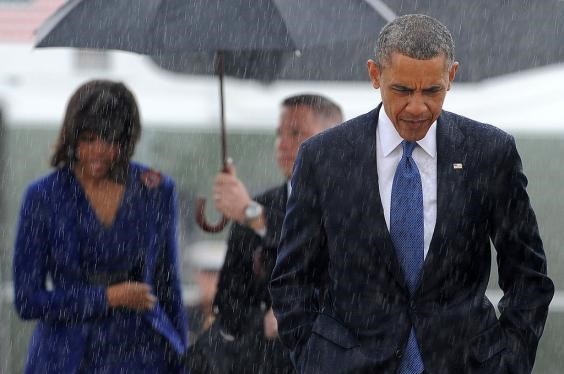 Tổng thống Mỹ Barack Obama để đầu trần bước đi giữa cơn mưa. (Nguồn: Getty Images).