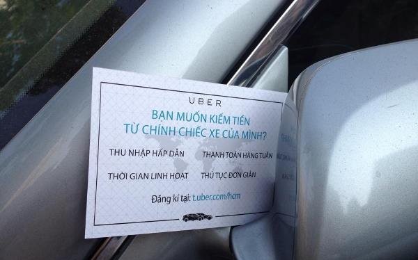 Một mẩu quảng cáo của Uber gắn trên kiếng xe chiếu hậu của chủ một xe hơi ở TPHCM