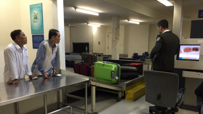 Hành khách đi nước ngoài chờ kiểm tra hành lý ký gửi tại phòng soi của hải quan sân bay quốc tế Tân Sơn Nhất chiều 7-4
