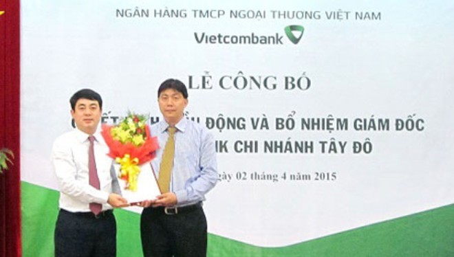 Ông Nghiêm Xuân Thành - Chủ tịch HĐQT VCB (bên trái) trao quyết định và tặng hoa chúc mừng ông Đỗ Trọng Phát - tân Giám đốc VCB Tây Đô