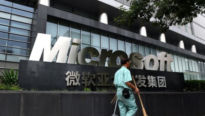 Một công nhân đi ngang qua văn phòng Microsoft tại Bắc Kinh (Ảnh: Bloomberg)