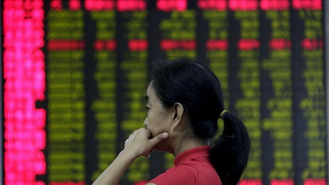 Một nhà đầu tư đăm chiêu theo dõi giá cổ phiếu trên một bảng điện tử tại Bắc Kinh - Ảnh: Reuters