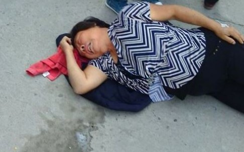 Một người phụ nữ ngã lăn ra sau khi hít phải khí độc. Ảnh: SCMP