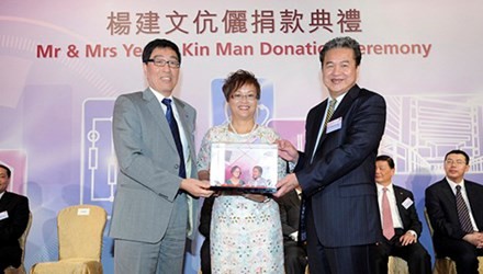 Yeung Kin-man (phải) nhận quà lưu niệm trong một buổi từ thiện. Ảnh: Bloomberg.