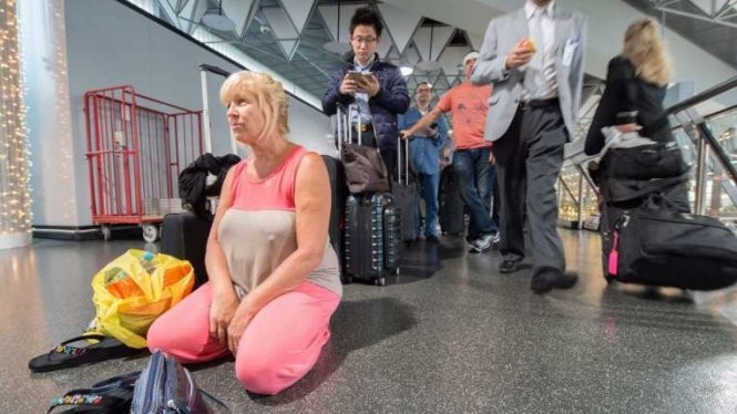 Một hành khách đang mệt mỏi chờ chuyến bay về Hawaii tại sân bay quốc tế ở Frankfurt, Đức hôm 8-11 - Ảnh: EPA
