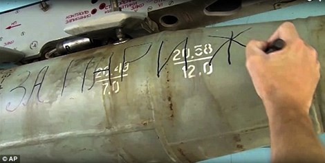 Một phi công Nga đang viết chữ “Vì Paris” lên một quả bom (Ảnh: AP) 