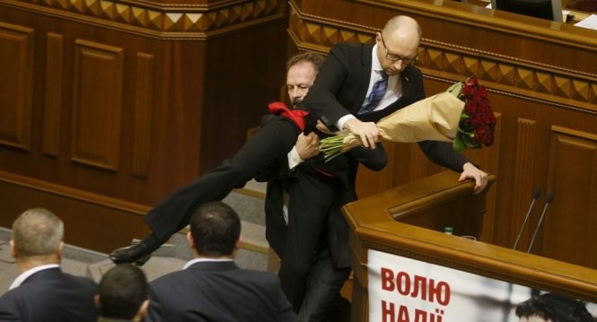 Nghị sĩ đảng đối lập nhấc bổng Thủ tướng Ukraine khi ông đang phát biểu - Ảnh: Reuters