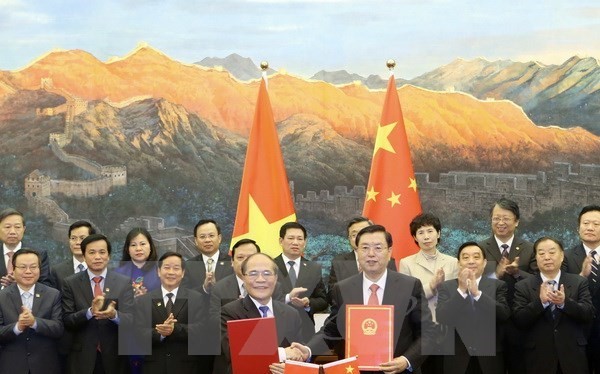 Chủ tịch Quốc hội Nguyễn Sinh Hùng và Chủ tịch Nhân đại Trương Đức Giang ký Thỏa thuận hợp tác giữa Quốc hội hai nước. (Ảnh: Nhan Sáng/TTXVN)