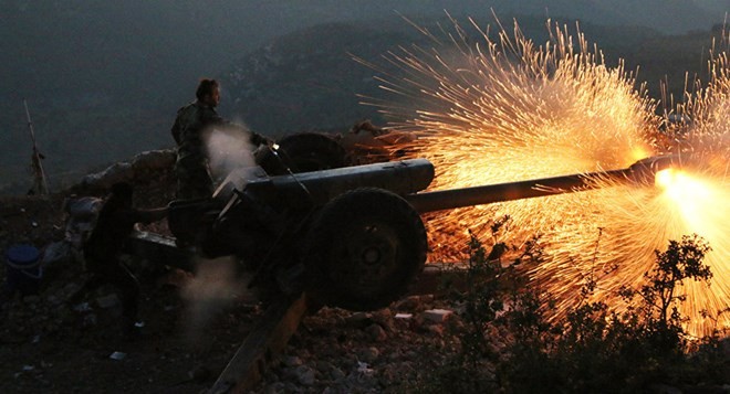 Một binh sĩ quân đội chính phủ Syria vận hành một khẩu pháo trong một cuộc tập trận tại Latakia, Syria.