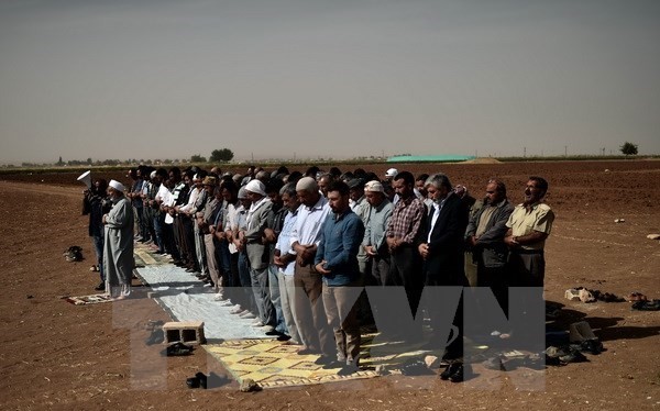 Người Kurd ở Thổ Nhĩ Kỳ và Syria cầu nguyện tại khu vực ngoại ô Suruc, tỉnh Sanliurfa (Thổ Nhĩ Kỳ) gần thị trấn Kobane ngày 10/10. (Nguồn: AFP/TTXVN)