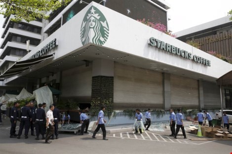  Công nhân dọn dẹp các mảnh vỡ bên ngoài quán cà phê Starbucks, gần khu vực tấn công hôm thứ Năm tại Jakarta.