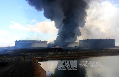 Khói bốc lên từ một kho dự trữ dầu tại nhà máy lọc dầu ở Ras Lanouf, Lybia ngày 23/1 sau các cuộc tấn công của IS. Ảnh: AFP/TTXVN