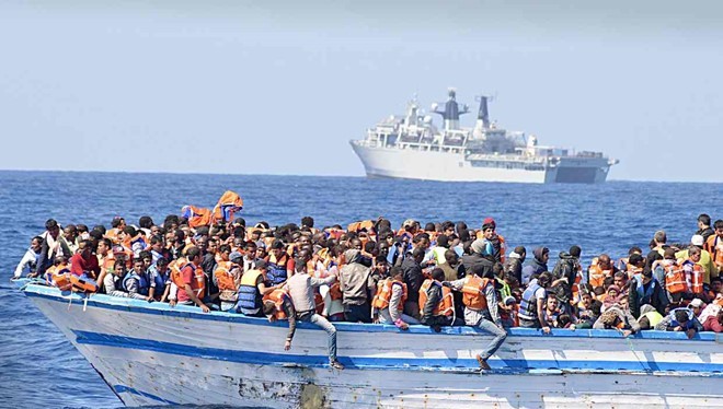 Hàng trăm người di cư chen chúc trên một thuyền nhỏ ở ngoài khơi Libya. Ảnh: REX