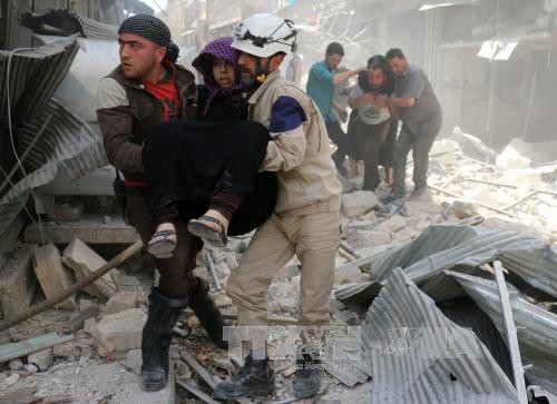 Lực lượng phòng vệ dân sự Syria sơ tán người bị thương khỏi hiện trường một vụ không kích tại Hayy Aqyul, thành phố Aleppo ngày 22/4. Ảnh: AFP/ TTXVN