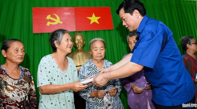 Bí thư Thành ủy Đinh La Thăng tặng quà cho các gia đình khó khăn ở xã đảo Thạnh An (TP.HCM) sáng 24-4 - Ảnh: Thuận Thắng